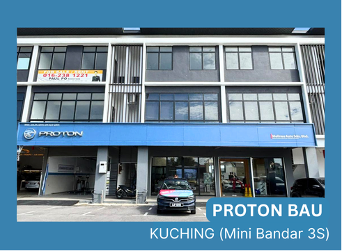 Proton Bau showroom in Kuching with blue signage and a car parked at the entrance, storefront visible.