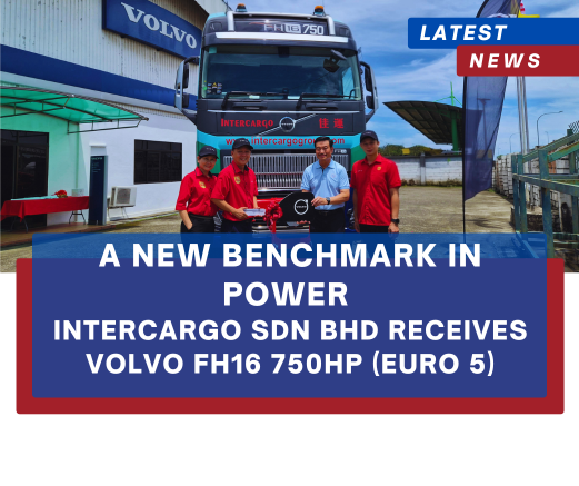 Group of five people in red shirts pose beside a Volvo FH16 750HP truck during a handover at Intercargo SDN BHD; banner reads 'A New Benchmark in Power'.